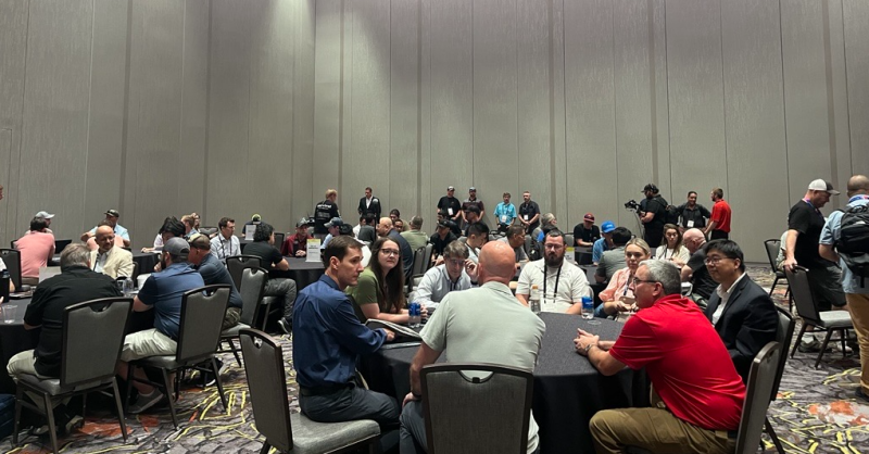 groups of people sitting at roundtables at Commercial UAV Expo having a discussion